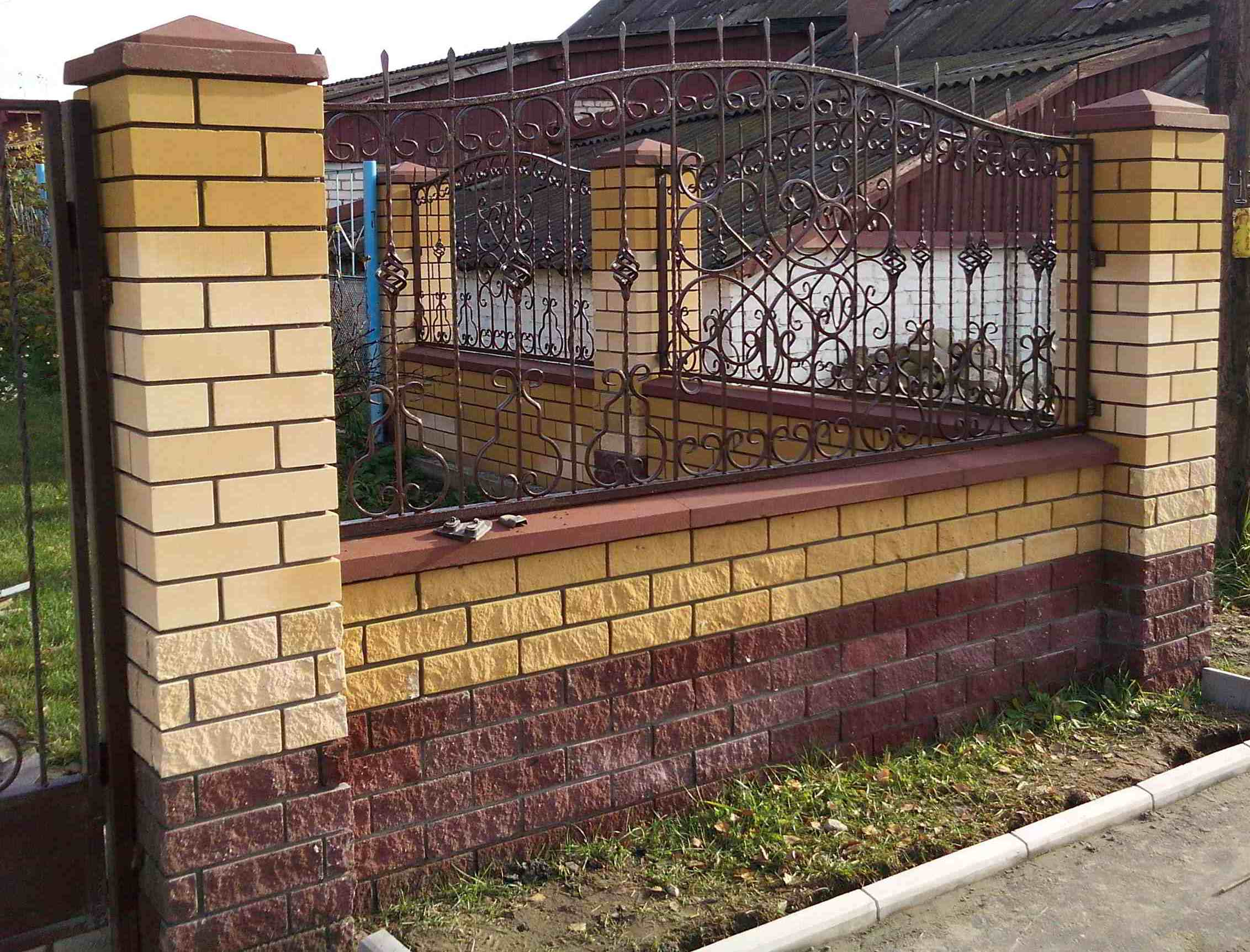 Забор из жёлтого кирпича с ковкой